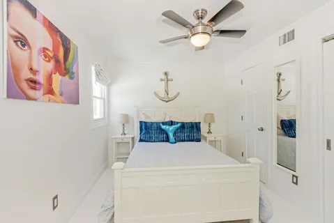 a bedroom with a bed and a fan