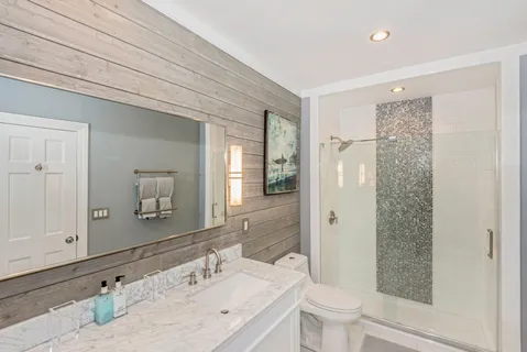 a bathroom with a sink a toilet and shower