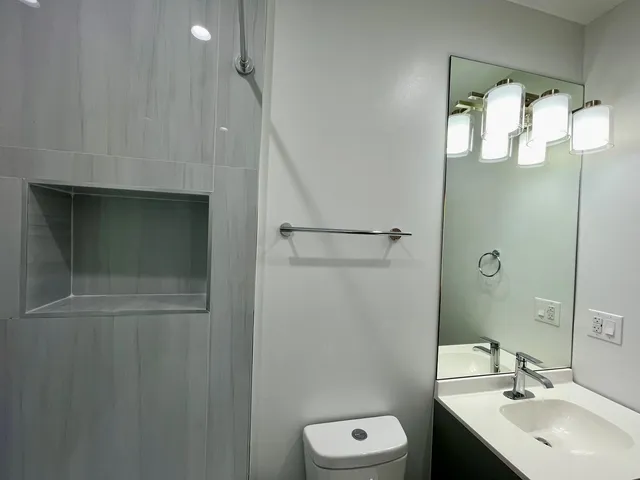 a bathroom with a sink a toilet and shower