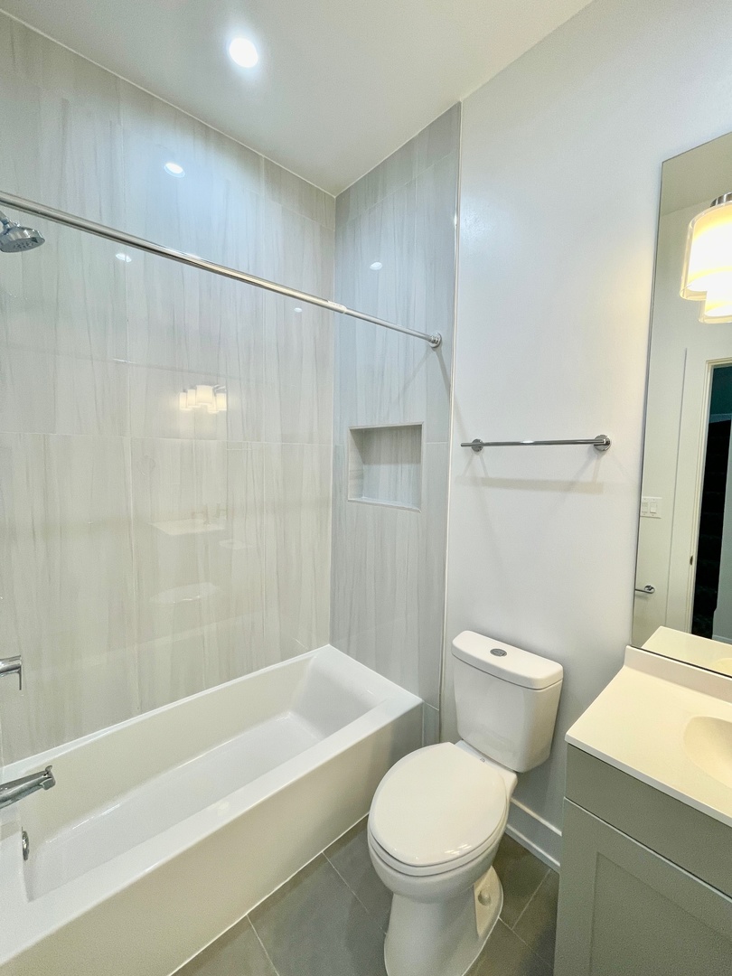 2238 West 24th Street, Unit 2F Chicago, IL 60608 - Photo 14 of 25 a white toilet sitting next to a bath tub and a shower
