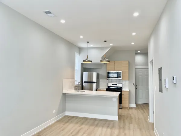a view of kitchen with kitchen island stainless steel appliances refrigerator and microwave