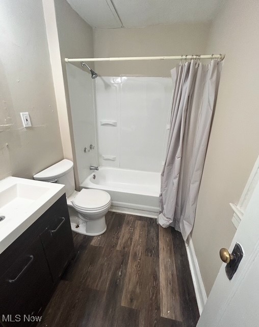 Full bathroom with hardwood / wood-style flooring, vanity, toilet, and shower / tub combo with curtain