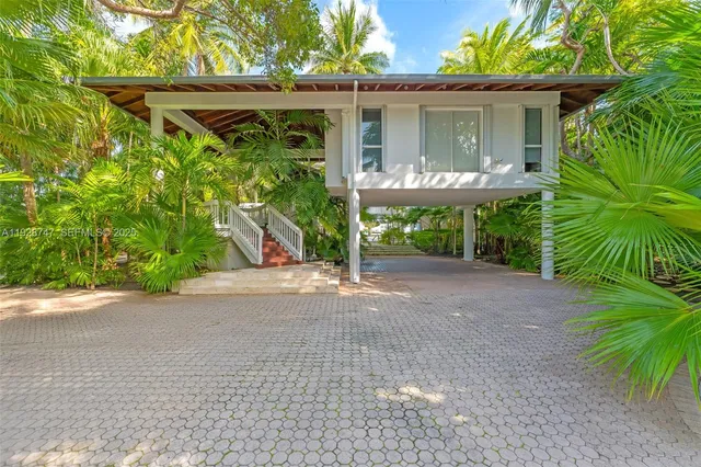 a couple of palm trees in front of yellow house
