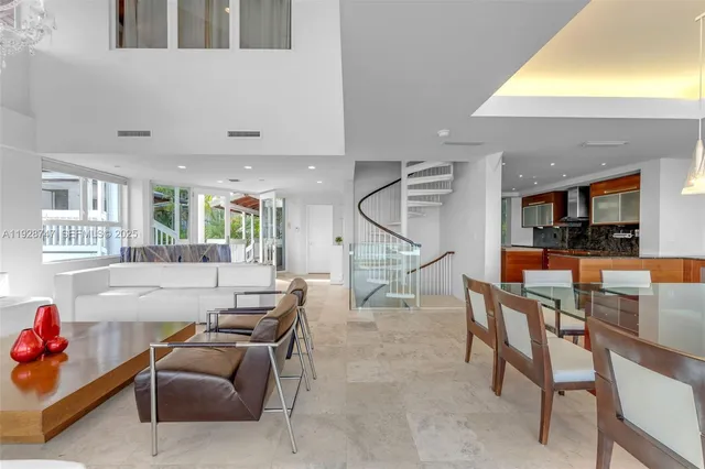 a living room with furniture kitchen view and a large window