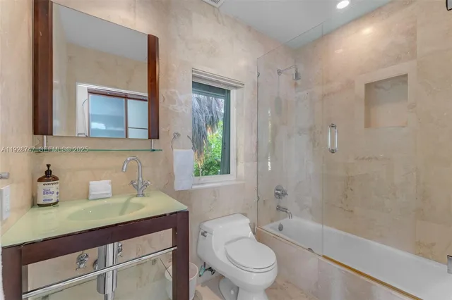 a bathroom with a granite countertop sink toilet and mirror
