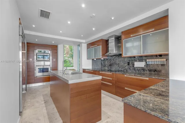 a kitchen with stainless steel appliances granite countertop a sink and a large window