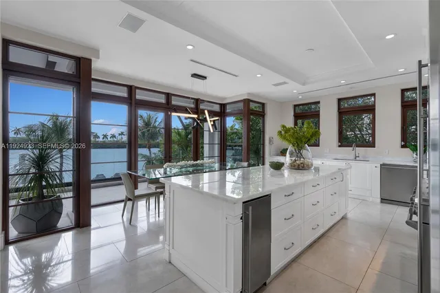 a kitchen with kitchen island granite countertop a refrigerator and a sink