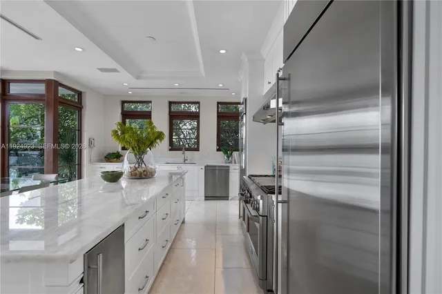 a kitchen with stainless steel appliances granite countertop a sink and a large window