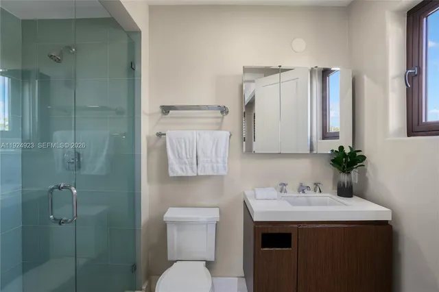 a bathroom with a sink toilet vanity and shower