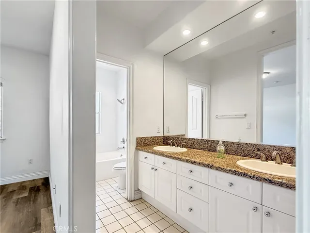 a bath room with a granite countertop sink and a mirror