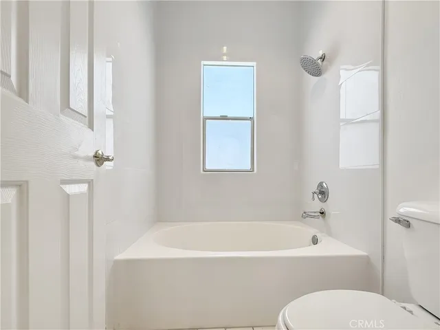 a white bath tub sitting next to a white toilet