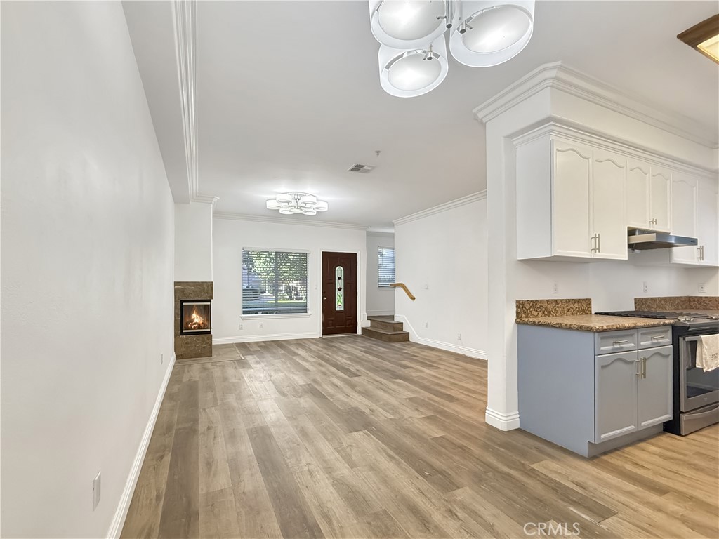 255 North Michigan Avenue, Unit 4 Pasadena, CA 91106 - Photo 4 of 20 a view of a kitchen with stainless steel appliances granite countertop a stove top oven a sink dishwasher and a fireplace with wooden floor