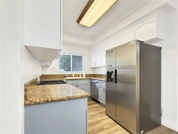 a kitchen with granite countertop a refrigerator and a sink