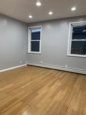 1503 76th Street, Unit 2 North Bergen, NJ 07047 - Photo 3 of 11 an empty room with wooden floor and windows