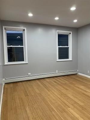 1503 76th Street, Unit 2 North Bergen, NJ 07047 - Photo 4 of 11 an empty room with wooden floor and windows