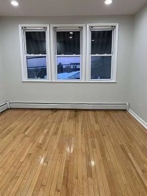 1503 76th Street, Unit 2 North Bergen, NJ 07047 - Photo 8 of 11 a view of an empty room with wooden floor and a window