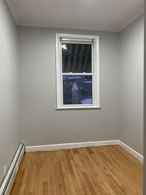 1503 76th Street, Unit 2 North Bergen, NJ 07047 - Photo 10 of 11 a view of an empty room with wooden floor and a window
