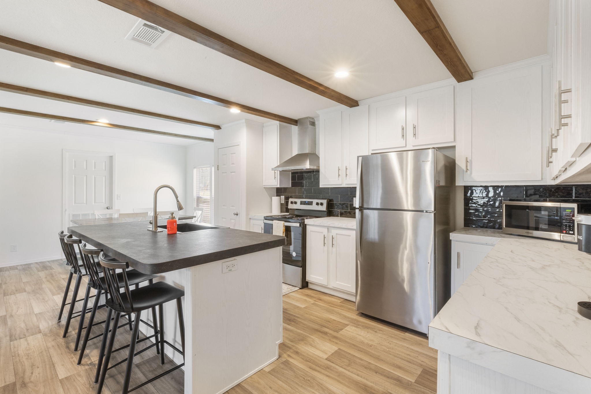 101 Hill Loop Road Somerville, TX 77879 - Photo 20 of 45 a kitchen with refrigerator cabinets and wooden floor