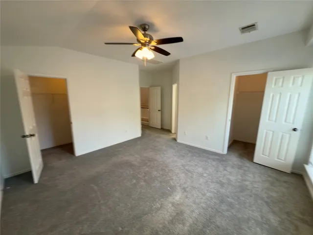 a view of an empty room with a ceiling fan