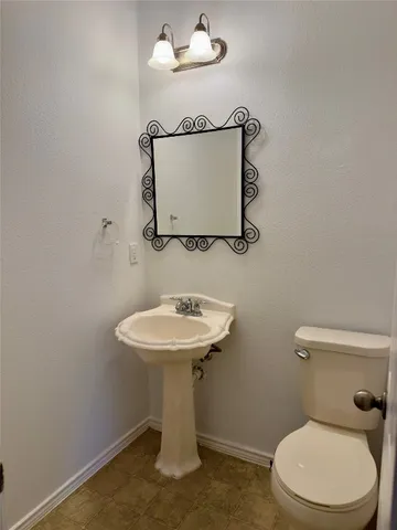 a bathroom with a sink a toilet and mirror