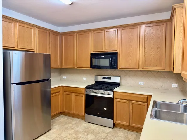 a kitchen with a refrigerator sink and cabinets