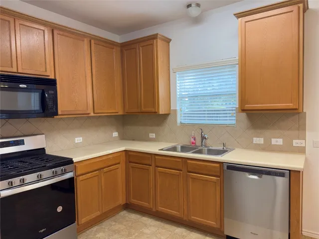 a kitchen with a sink stove and cabinets