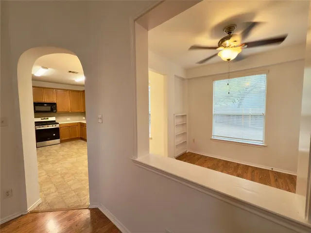 a view of a hallway with a chandelier fan and wooden floor