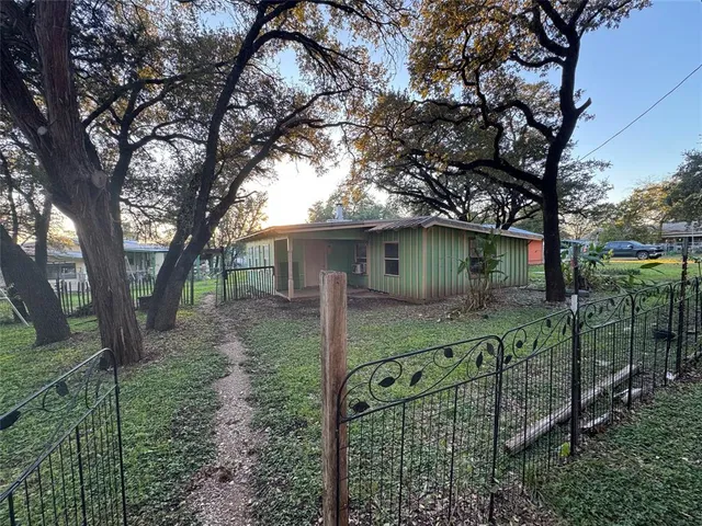 a view of a house with a tree in the yard