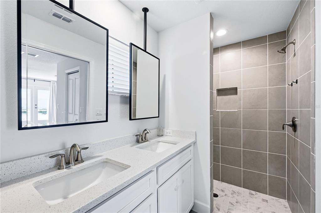 8452 Dorsey Street Spring Hill, FL 34608 - Photo 11 of 28 a bathroom with a double vanity sink mirror and shower