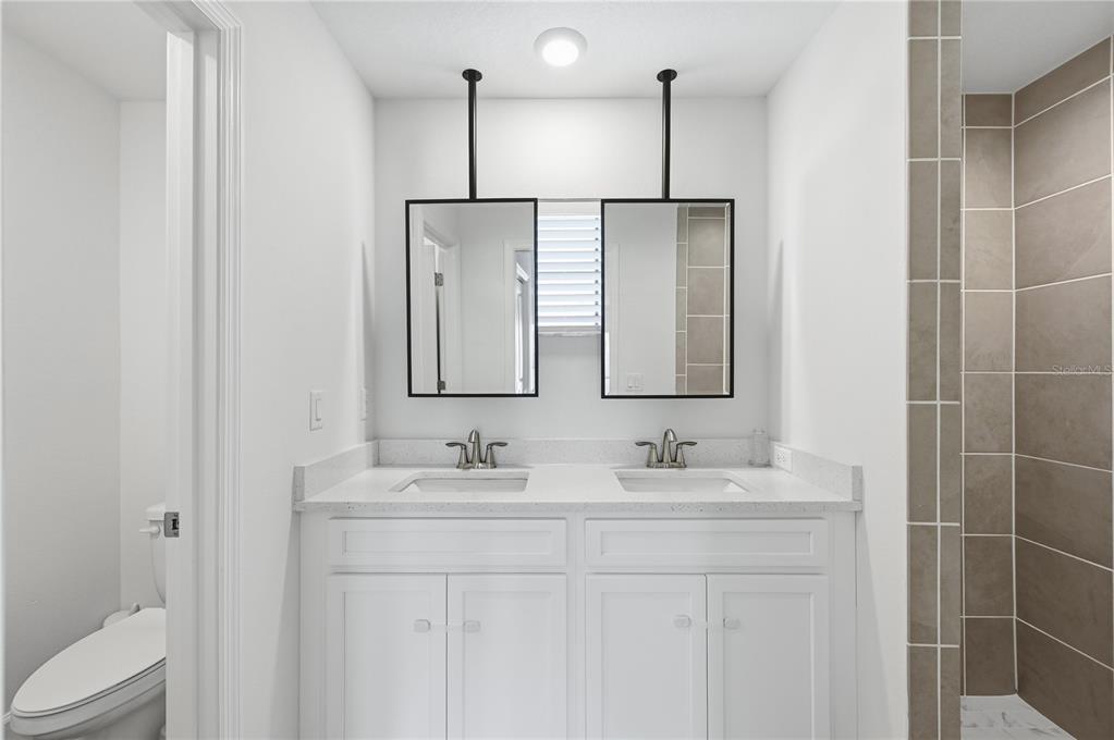 8452 Dorsey Street Spring Hill, FL 34608 - Photo 12 of 28 a bathroom with a double vanity sink and a mirror