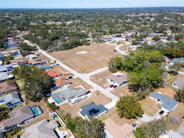 an aerial view of residential houses with outdoor space and parking