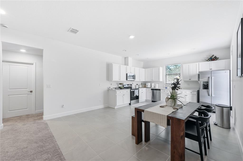 8452 Dorsey Street Spring Hill, FL 34608 - Photo 7 of 28 a kitchen with stainless steel appliances a table and chairs in it