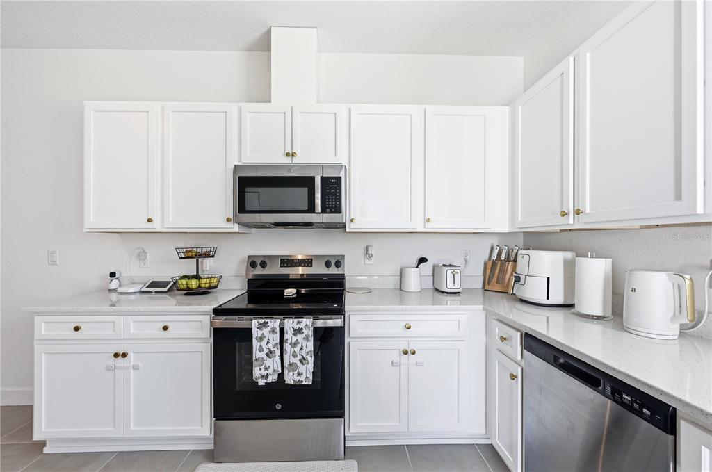 8452 Dorsey Street Spring Hill, FL 34608 - Photo 8 of 28 a kitchen with granite countertop white cabinets sink and stainless steel appliances