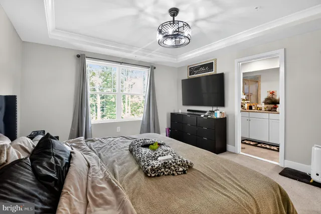 a bedroom with a bed television and a window