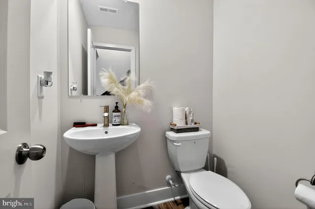 a bathroom with a sink mirror toilet and a mirror