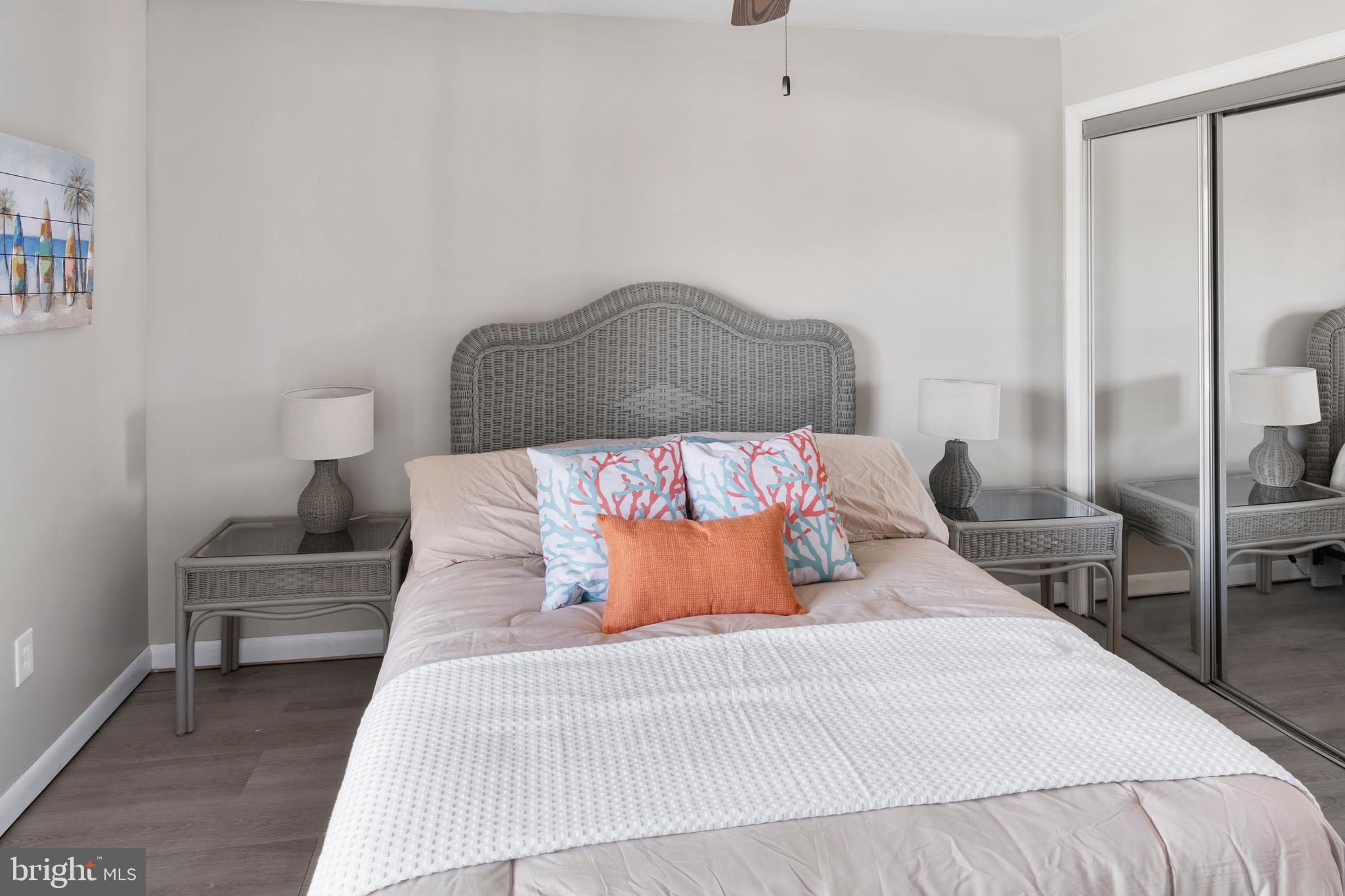 170 Captains Quarters Road, Unit 201 Ocean City, MD 21842 - Photo 30 of 65 a bedroom with a bed and wooden floor