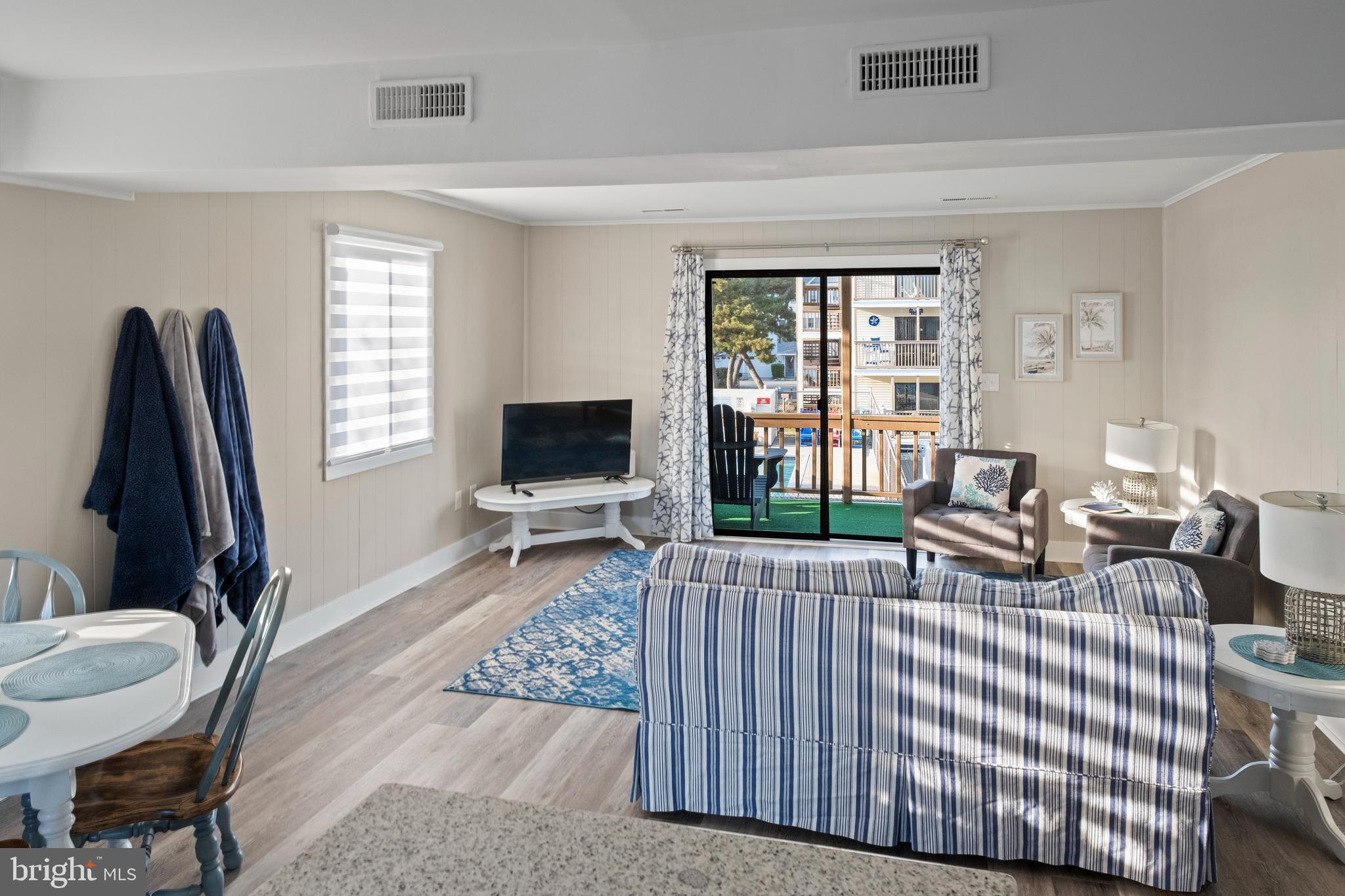 170 Captains Quarters Road, Unit 201 Ocean City, MD 21842 - Photo 31 of 65 a living room with furniture a flat screen tv and a large window