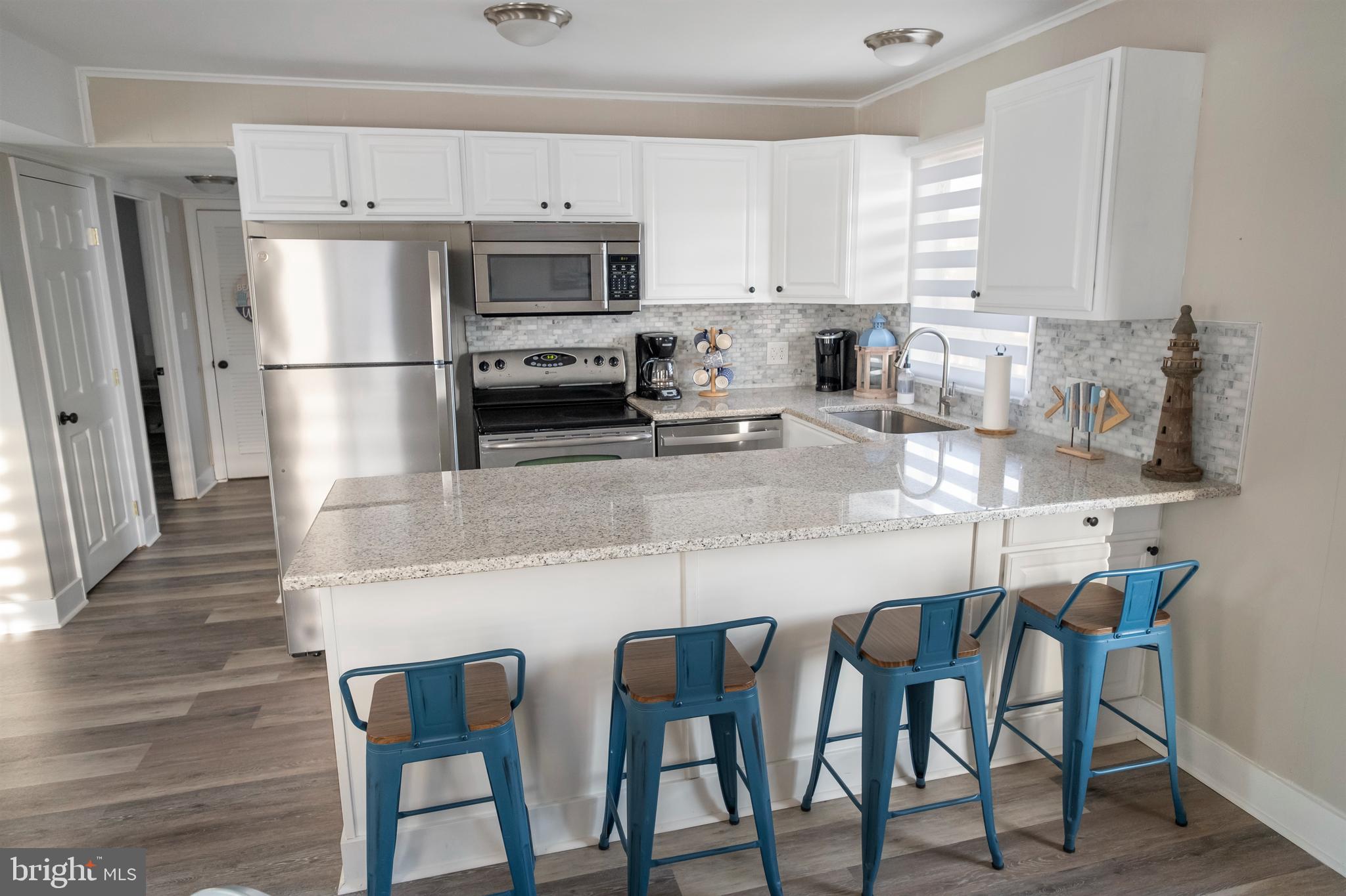 170 Captains Quarters Road, Unit 201 Ocean City, MD 21842 - Photo 33 of 65 a kitchen with granite countertop white cabinets and stainless steel appliances