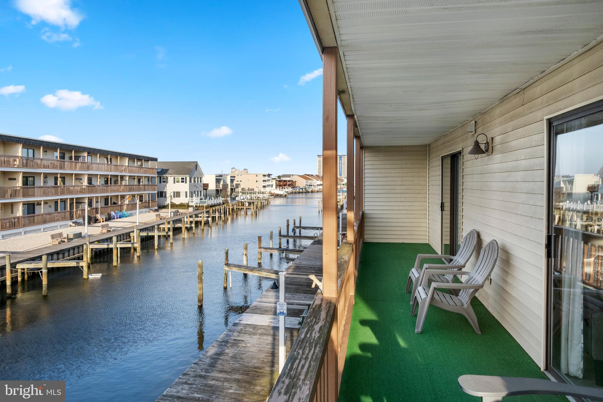 170 Captains Quarters Road, Unit 201 Ocean City, MD 21842 - Photo 52 of 65 a view of a chairs and table on the deck in front of house