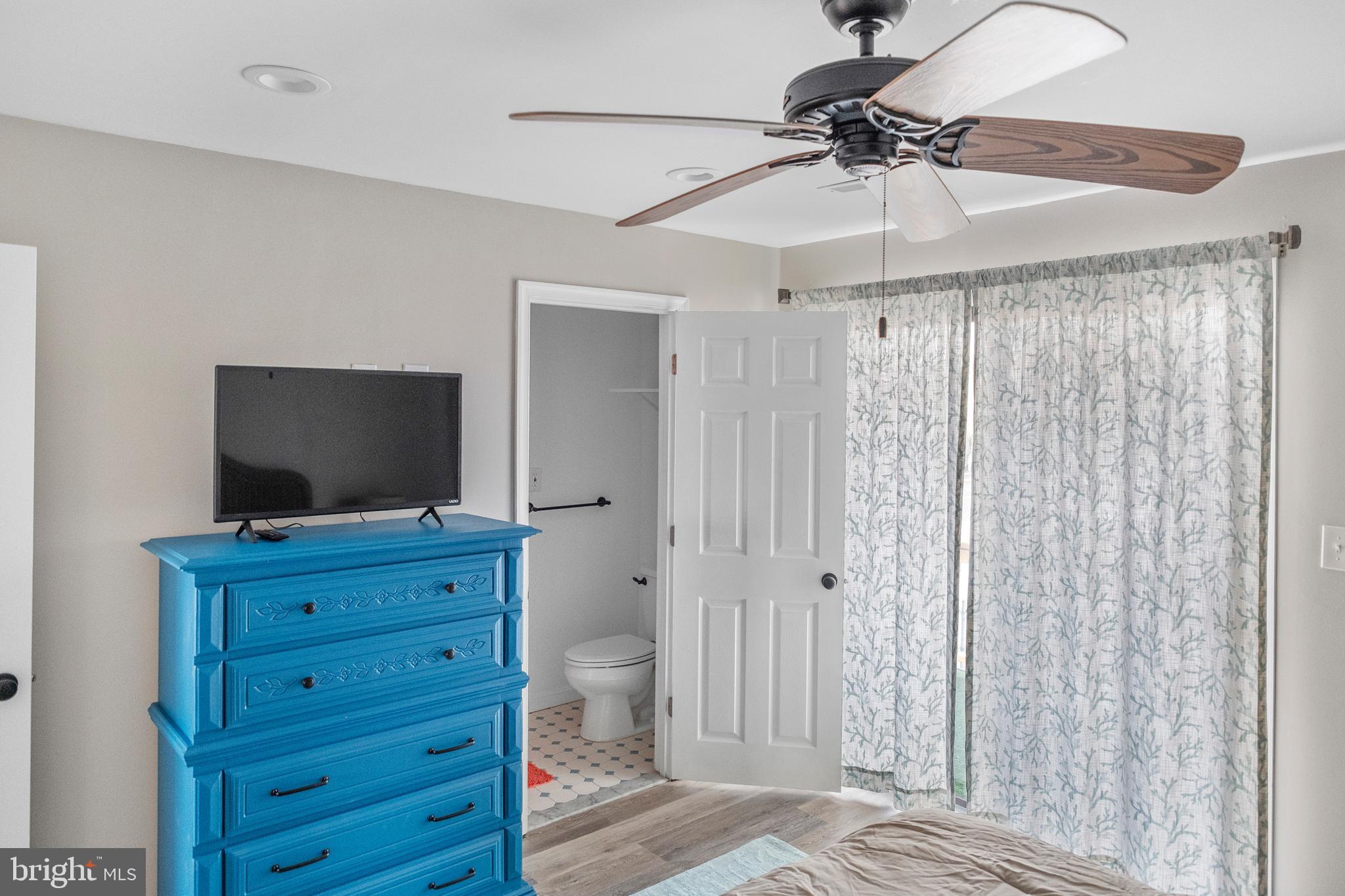 170 Captains Quarters Road, Unit 201 Ocean City, MD 21842 - Photo 60 of 65 a room with a bed and a flat tv screen on a dresser