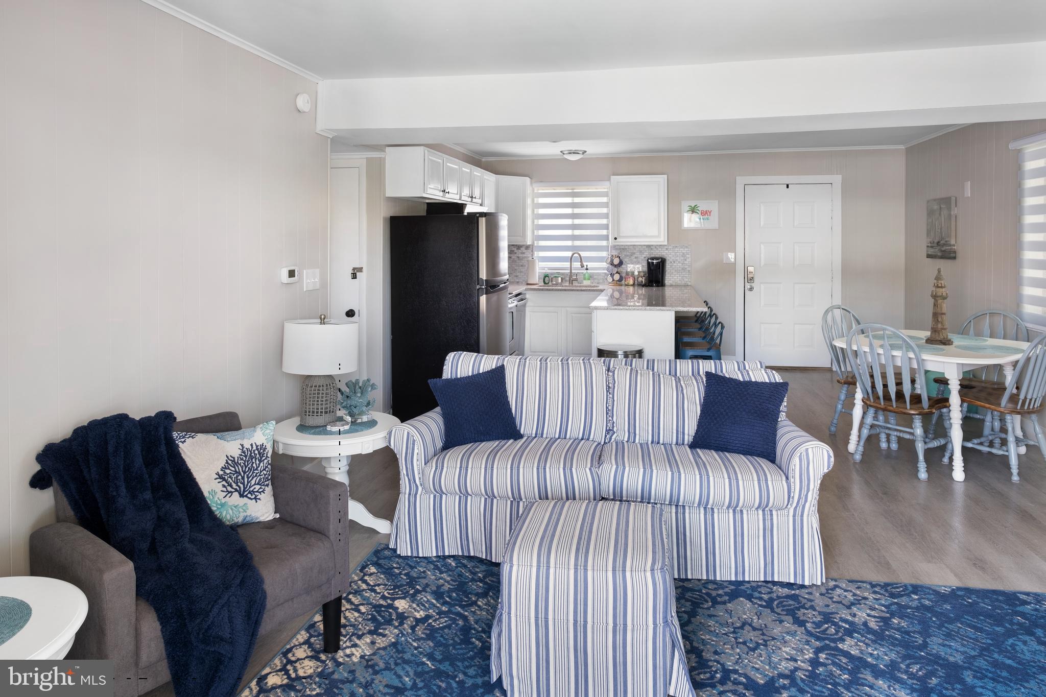 170 Captains Quarters Road, Unit 201 Ocean City, MD 21842 - Photo 8 of 65 a living room with furniture a dining table and a refrigerator