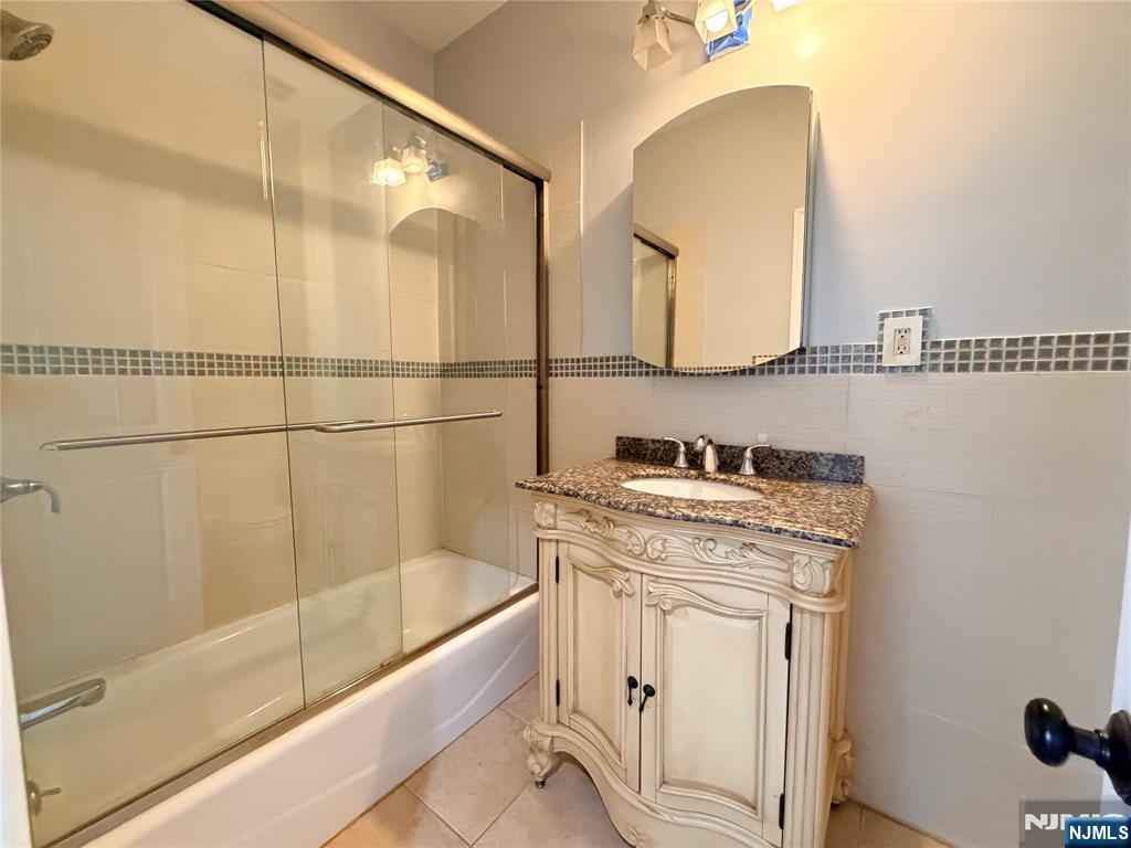 227 Washington Avenue Hackensack, NJ 07601 - Photo 29 of 33 a bathroom with a sink a mirror and a bathtub