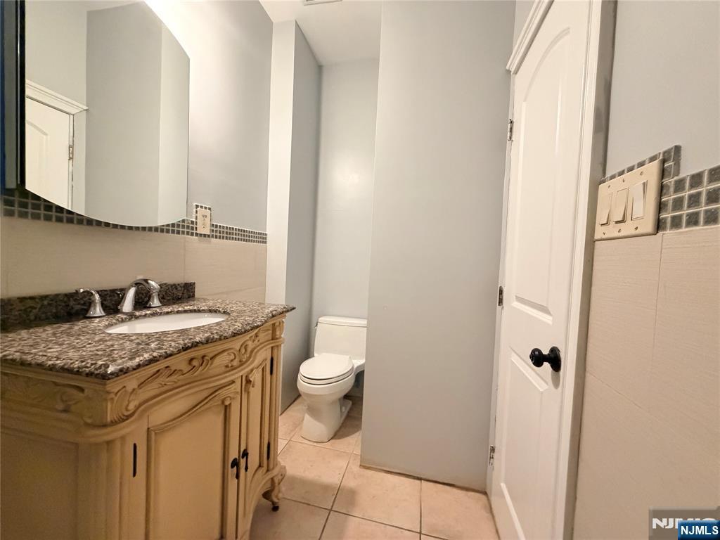 227 Washington Avenue Hackensack, NJ 07601 - Photo 30 of 33 a bathroom with a granite countertop sink and a toilet