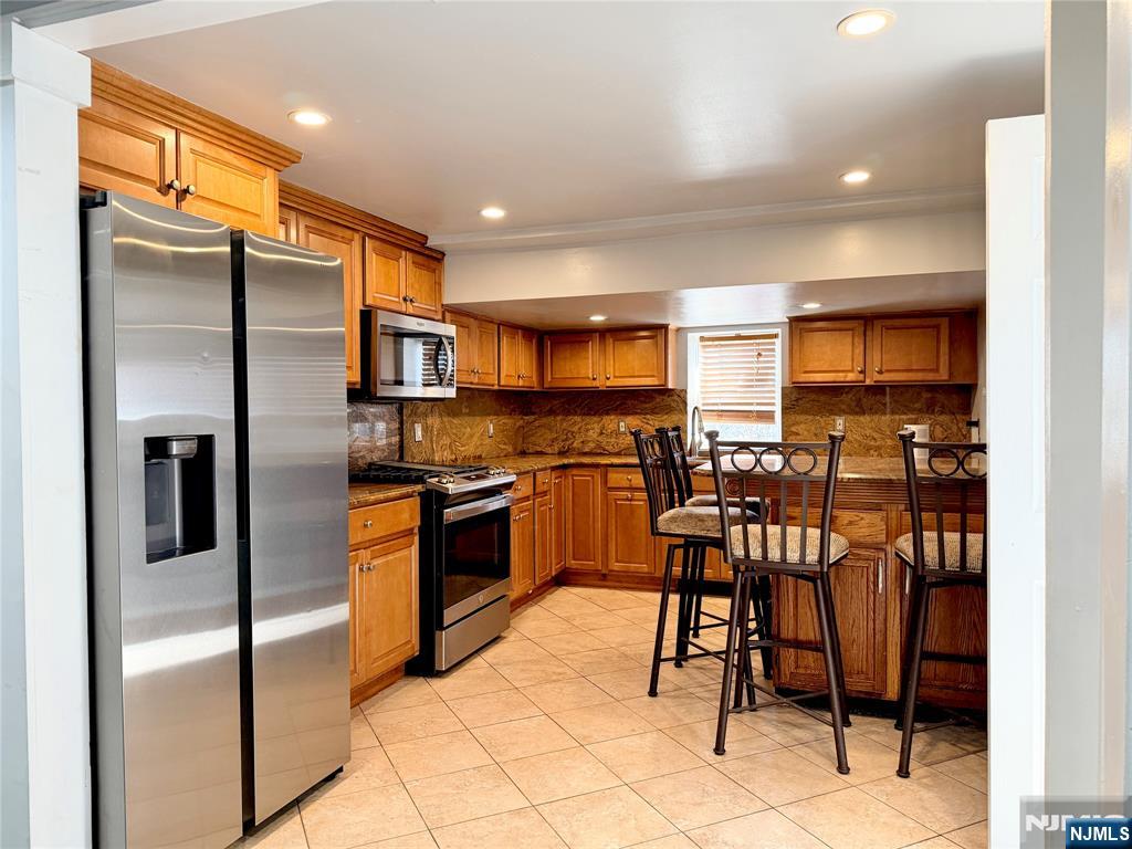 227 Washington Avenue Hackensack, NJ 07601 - Photo 6 of 33 a kitchen with granite countertop a refrigerator and a stove top oven