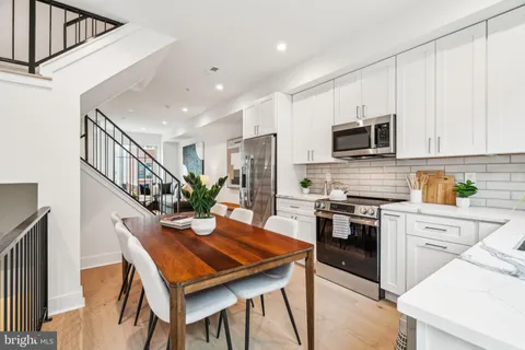 a kitchen with furniture wooden floor and stainless steel appliances