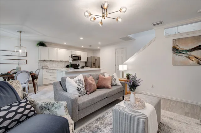 a living room with furniture and kitchen view