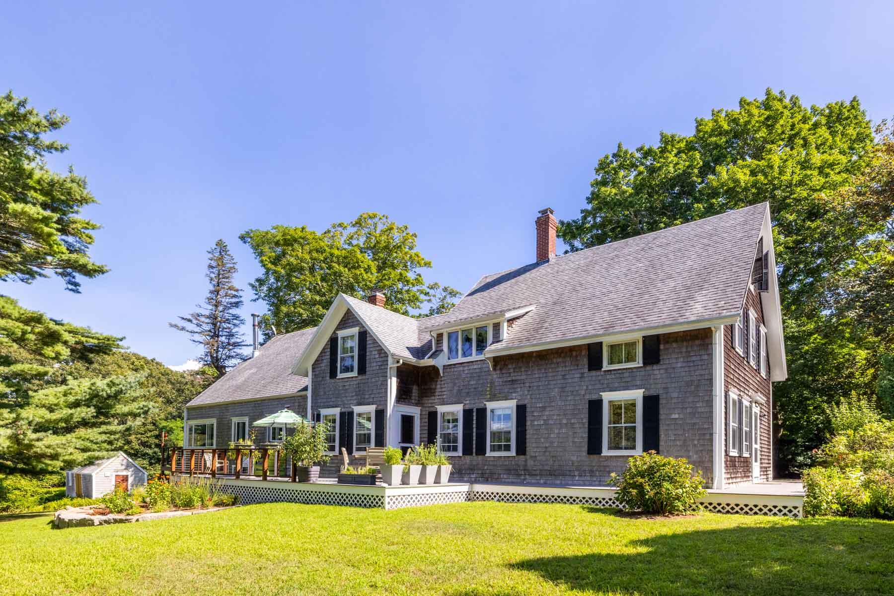 420 Lamberts Cove Road West Tisbury, MA 02568 - Photo 7 of 18 a front view of a house with a yard table and chairs