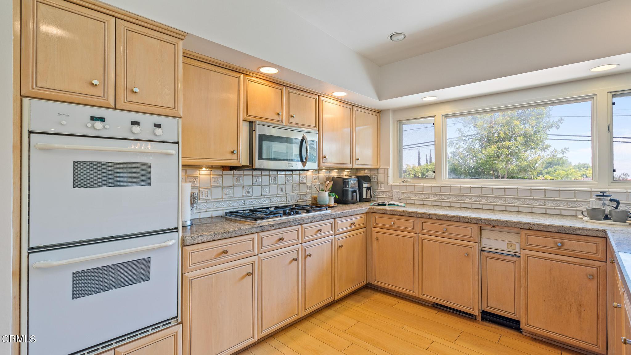 5212 Pizzo Ranch Road La Canada Flintridge, CA 91011 - Photo 11 of 44 a kitchen with white cabinets and white appliances
