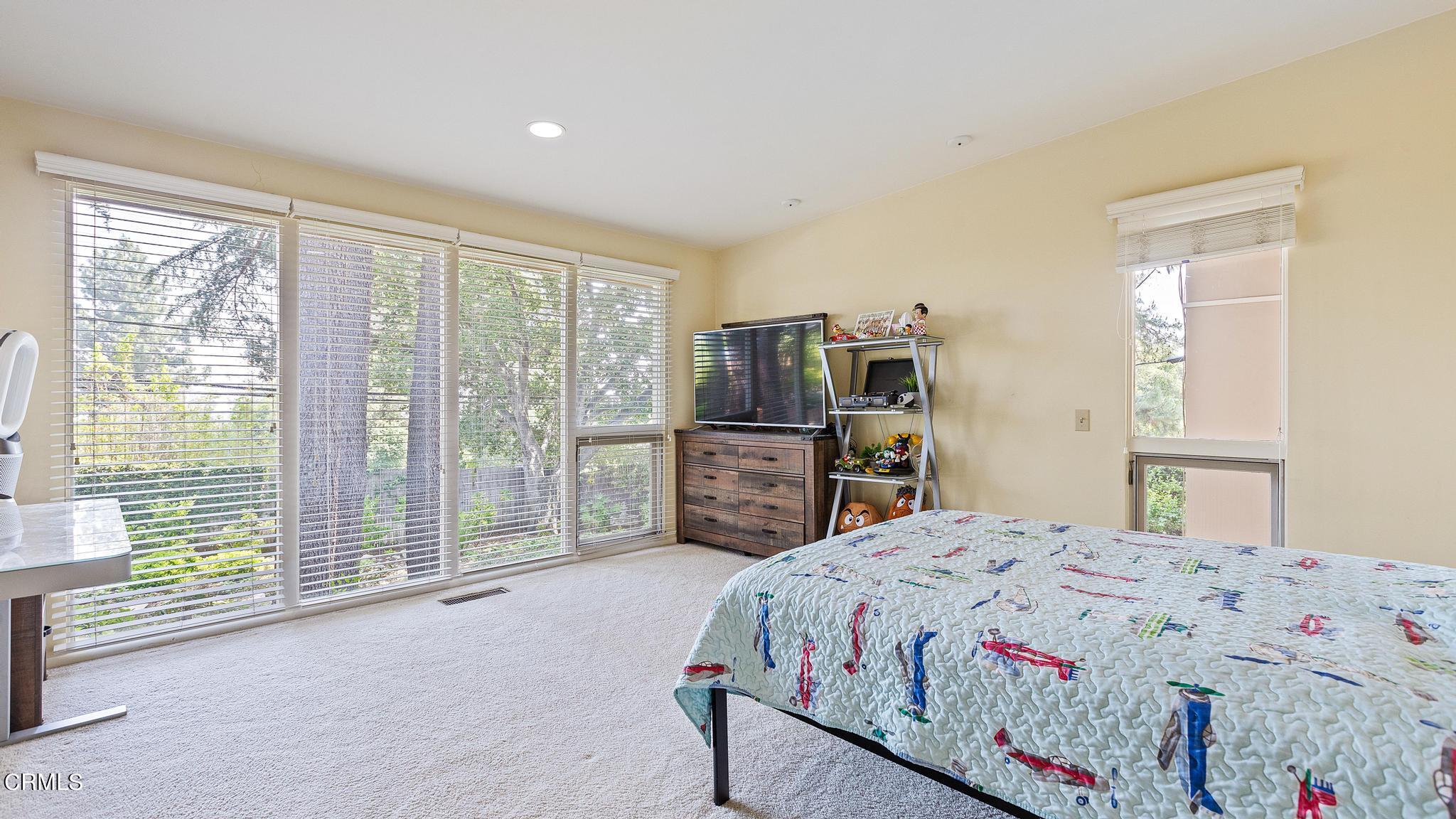 5212 Pizzo Ranch Road La Canada Flintridge, CA 91011 - Photo 24 of 44 a bedroom with a bed a dresser and a large window