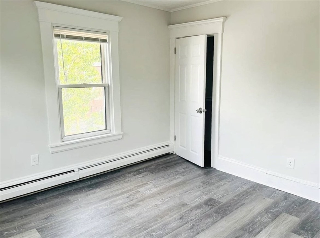 15 Ellsworth Street, Unit 2 Somerville, MA 02145 - Photo 11 of 16 an empty room with wooden floor and windows